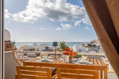 a table with a bowl of fruit on top of a balcony at Deluxe Flat by Albufeira Holidays in Albufeira