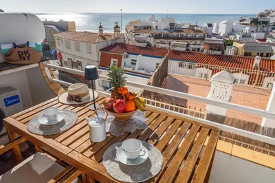 a table with a bowl of fruit on a balcony at Deluxe Flat by Albufeira Holidays in Albufeira