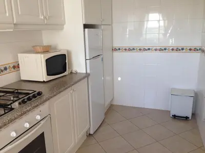 a kitchen with a microwave and a refrigerator at Albufeira Marina Villa by Umbral in Albufeira