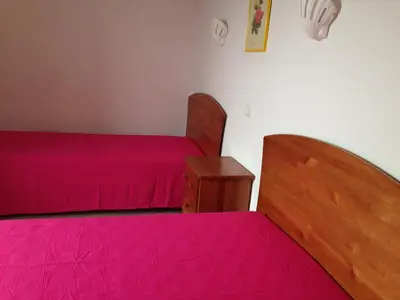 a bedroom with two beds with pink sheets and a table at Albufeira Marina Villa by Umbral in Albufeira