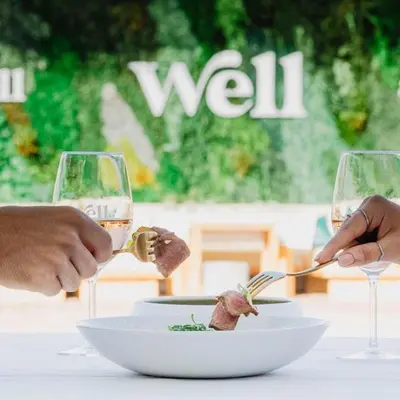 two people eating food on a table with wine glasses at Stunning 3 bed Villa in Vale do Lobo with Resort Membership 3 mins From Beach and Golf in Loulé