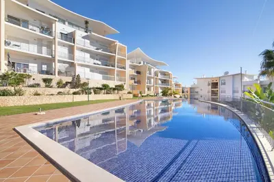 a swimming pool in front of a apartment building at Apartamento da Ourada Marina luz in Albufeira
