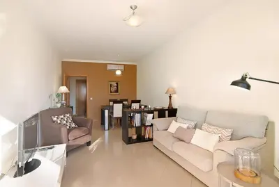 a living room with a couch and a tv at Apartamento da Ourada Marina luz in Albufeira