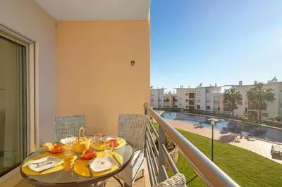 a balcony with a table and a view of a pool at Apartamento da Ourada Marina luz in Albufeira