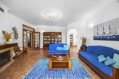 a living room with a blue couch and a table at Villa Casa do Barrocal by Villa Plus in Loulé