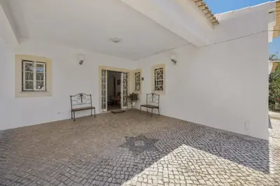 an empty white room with two chairs on a tile floor at Villa Casa do Barrocal by Villa Plus in Loulé