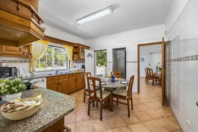 a kitchen with a table and chairs and a dining room at Villa Casa do Barrocal by Villa Plus in Loulé