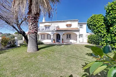a large white house with a palm tree in the yard at Casal dos Machados - Vista Mar in Benfarras