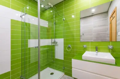 a green tiled bathroom with a sink and a shower at Fantastic Townhouse with Pool and Sea Views in Albufeira