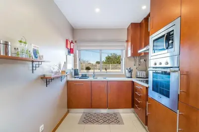 a kitchen with wooden cabinets and a sink at Fantastic Townhouse with Pool and Sea Views in Albufeira