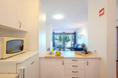 a kitchen with a counter with a microwave and a tv at Apartamento LIMA by Sunnyway in Albufeira