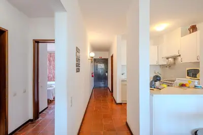 a kitchen with white cabinets and a red tile floor at Apartamento LIMA by Sunnyway in Albufeira