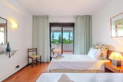 a bedroom with two beds and a balcony at Apartamento LIMA by Sunnyway in Albufeira