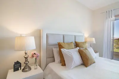 a white bedroom with a bed and a lamp at Apartamento Loft 39 by Sunnyway in Albufeira