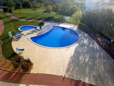 an overhead view of two large swimming pools with chairs at Apartamento Loft 39 by Sunnyway in Albufeira