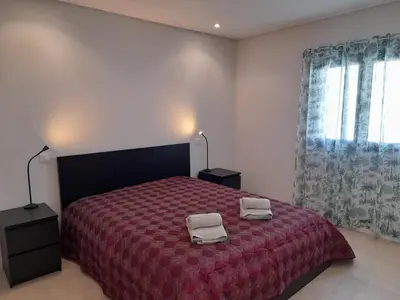a bedroom with a red bed with two towels on it at @Rocking Apartments - Quinta da Alvorada in Albufeira