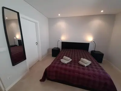 a bedroom with a bed with two white towels on it at @Rocking Apartments - Quinta da Alvorada in Albufeira