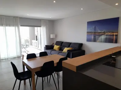 a living room with a couch and a table and chairs at @Rocking Apartments - Quinta da Alvorada in Albufeira