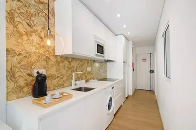 a kitchen with white cabinets and a sink at África Minha in Vilamoura