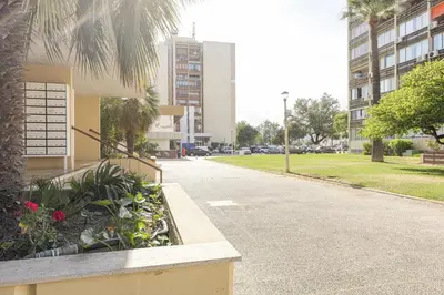 a street in a city with buildings and a palm tree at MARC - Vilamoura in Vilamoura