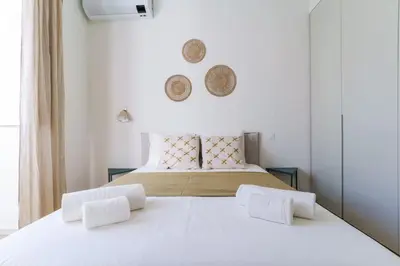 a bedroom with a large white bed with two pillows at Modern & Bright Faro Mercado Apt 12 by Lisbeyond in Faro