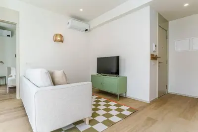 a living room with a white couch and a television at Modern & Bright Faro Mercado Apt 12 by Lisbeyond in Faro