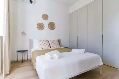 a white bedroom with two beds with towels on them at Modern & Bright Faro Mercado Apt 12 by Lisbeyond in Faro