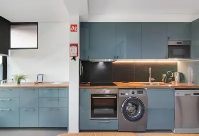 a kitchen with blue cabinets and a washing machine at Cosy Loft in Vilamoura in Vilamoura