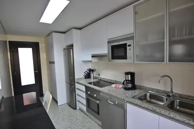a kitchen with a sink and a microwave at Monte Laguna Apartment in Quarteira