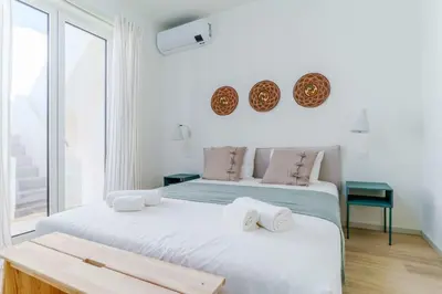 two beds in a room with a window at Modern & Cozy Faro Mercado Apt 21 by Lisbeyond in Faro