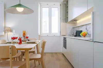 a kitchen with a table and a dining room at Modern & Cozy Faro Mercado Apt 21 by Lisbeyond in Faro