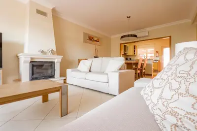 a living room with a white couch and a fireplace at Beautiful Family T3 Townhouse with Pool Vilamoura in Vilamoura