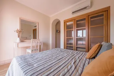 a bedroom with a large bed and a mirror at Beautiful Family T3 Townhouse with Pool Vilamoura in Vilamoura