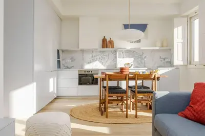 a kitchen with a table and a blue couch at Modern & Bright - Faro Mercado Apt 22 by Lisbeyond in Faro