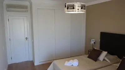 a bedroom with a bed with two white slippers on it at Vila Atlantida Apartment in Vilamoura