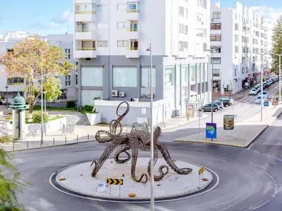 a metal statue of an octopus on a city street at AL - Apartamento Quarteira Avenida in Quarteira