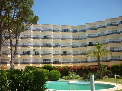 an apartment building with a swimming pool in front of it at Apartamentos Mar-Bel Sol in Vilamoura