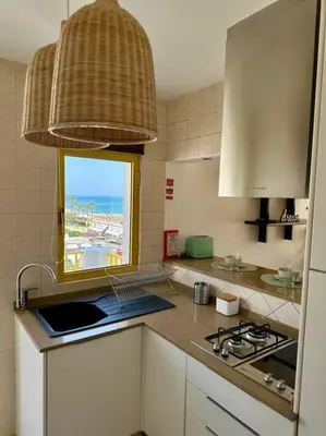 a kitchen with a laptop on a counter with a window at TOM's House - T2 Sea View in Quarteira