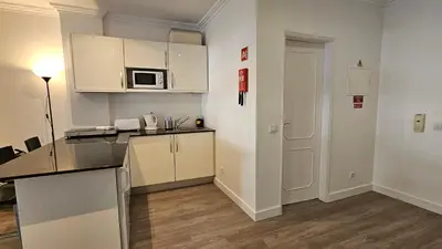 a kitchen with white cabinets and a counter top at Original Studio Downtown in Albufeira