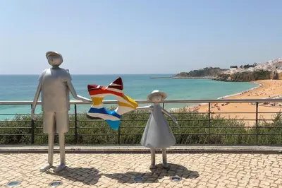 two statues of a man and a woman standing next to a beach at Original Studio Downtown in Albufeira