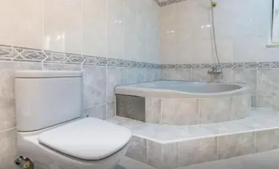 a bathroom with a toilet and a bath tub at Suites & Beds DP Albufeira in Albufeira