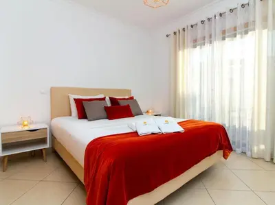 a bedroom with a large bed with a red blanket at Magnólia AB House by Stay ici Algarve Holiday Rental in Albufeira