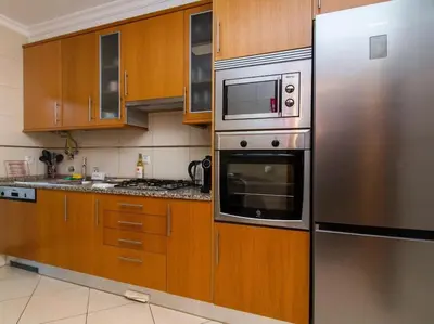 a kitchen with wooden cabinets and stainless steel appliances at Magnólia AB House by Stay ici Algarve Holiday Rental in Albufeira