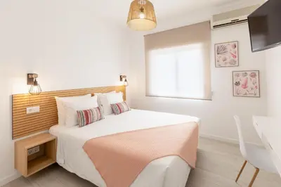 a bedroom with a bed and a window and a television at Faro Guest Apartments in Faro