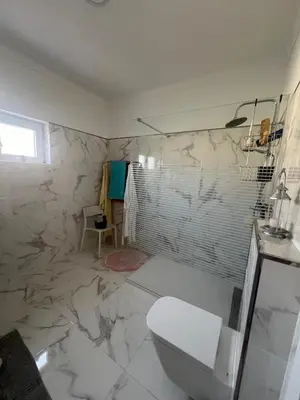 a bathroom with a toilet and a marble wall at Casa Amar in Loulé