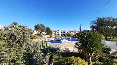 a resort with a swimming pool and palm trees at Excellent 1 Bedroom Villa - em Clube Albufeira Garden Village in Albufeira
