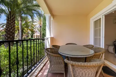 a balcony with a table and chairs and palm trees at Palmyra by Intiholidays in Vilamoura