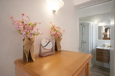 a bathroom with a vanity with flowers and a mirror at Welcoming Oasis 500m Beach AC Wi-Fi Pool Balcony in Albufeira