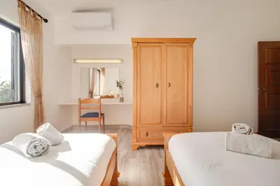 a bedroom with two beds and a cabinet at Welcoming Oasis 500m Beach AC Wi-Fi Pool Balcony in Albufeira