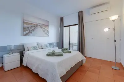 a bedroom with a large white bed with towels on it at VILA MAGNA - Apart renovado para 4 com piscina e Ar condicionado in Albufeira